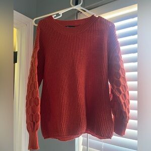 Women’s orange sweater with sleeve detail